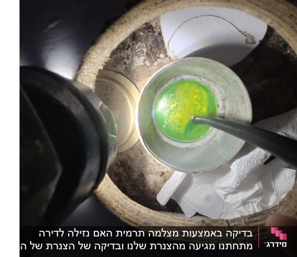 תמונה של צינור עם נוזל ירוק בתוך חור בקיר
